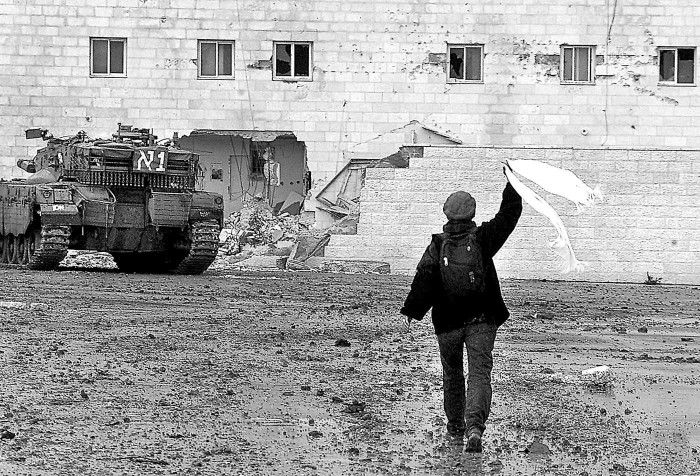 Eiropas miera aktīviste vicina baltu šalli izraēliešu karavīru priekšā pie Jāsīra Arafata mītnes Rāmallāhā (Foto - EPA/A.F.I.)