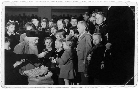 Mazais Zigis saņem no Ziemassvētku vecīša Kārļa Ulmaņa dāvātus cimdus (Foto no Račiņu ģimenes arhīva)